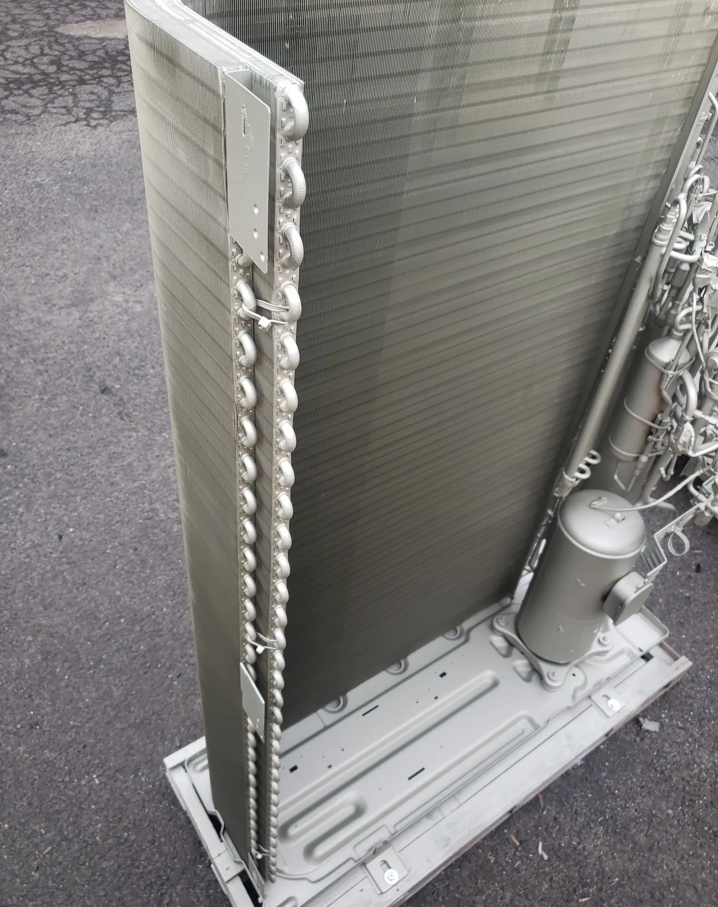 Technician applying protective coating spray to an AC coil.